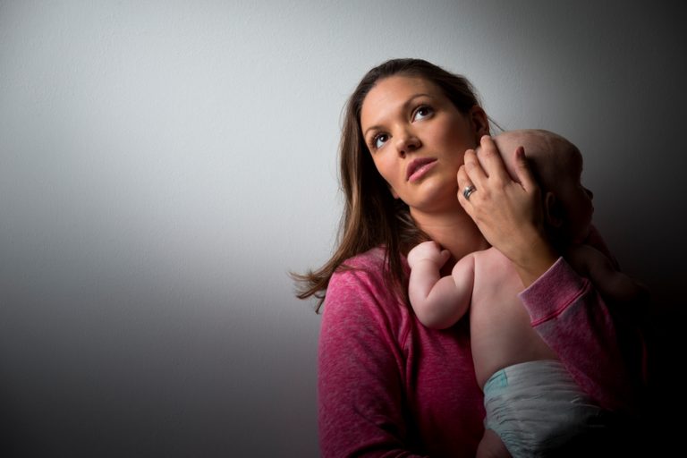 Stressed mother holding her baby.