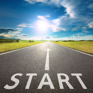 Empty asphalt road with a sign start against sun