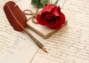 red rose flower, old letters and antique feather pen. sentimental vintage background. selective focus